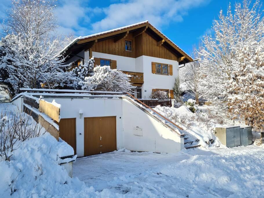 a house covered in snow with a garage at Ferienwohnung Freymiller in Bad Kohlgrub