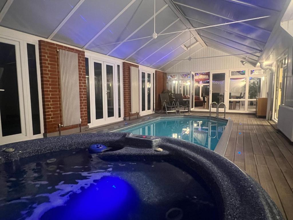 a large swimming pool in a house with a large pool at Broadway Pool House with Sauna & Jacuzzi in Herne Bay