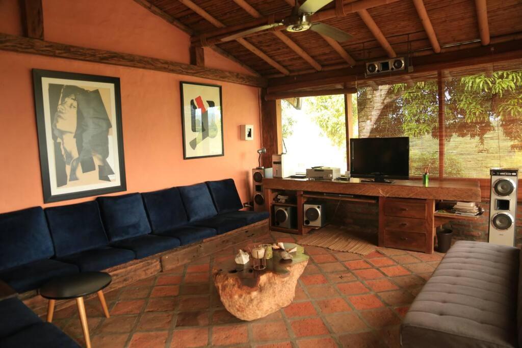 uma sala de estar com um sofá azul e uma televisão em Finca La Colina em Armênia
