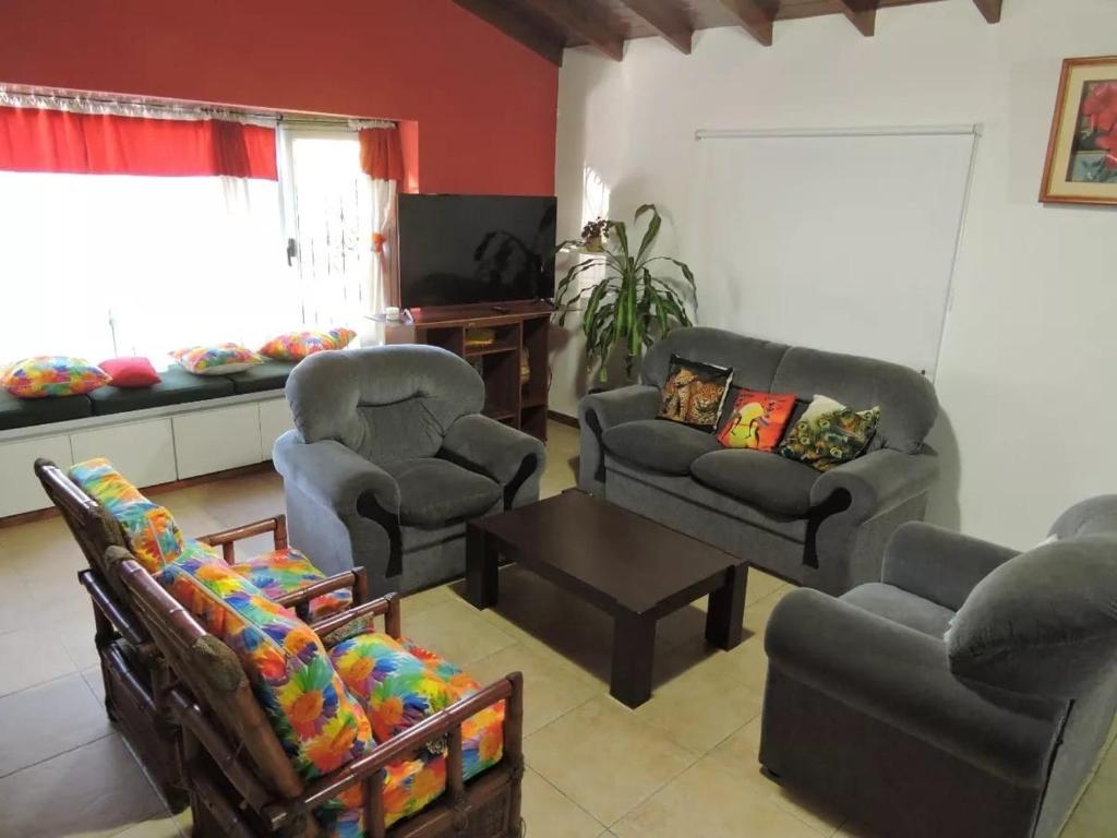 uma sala de estar com duas cadeiras, um sofá e uma mesa em Casa en Pinamar 75milxdia em Ostende