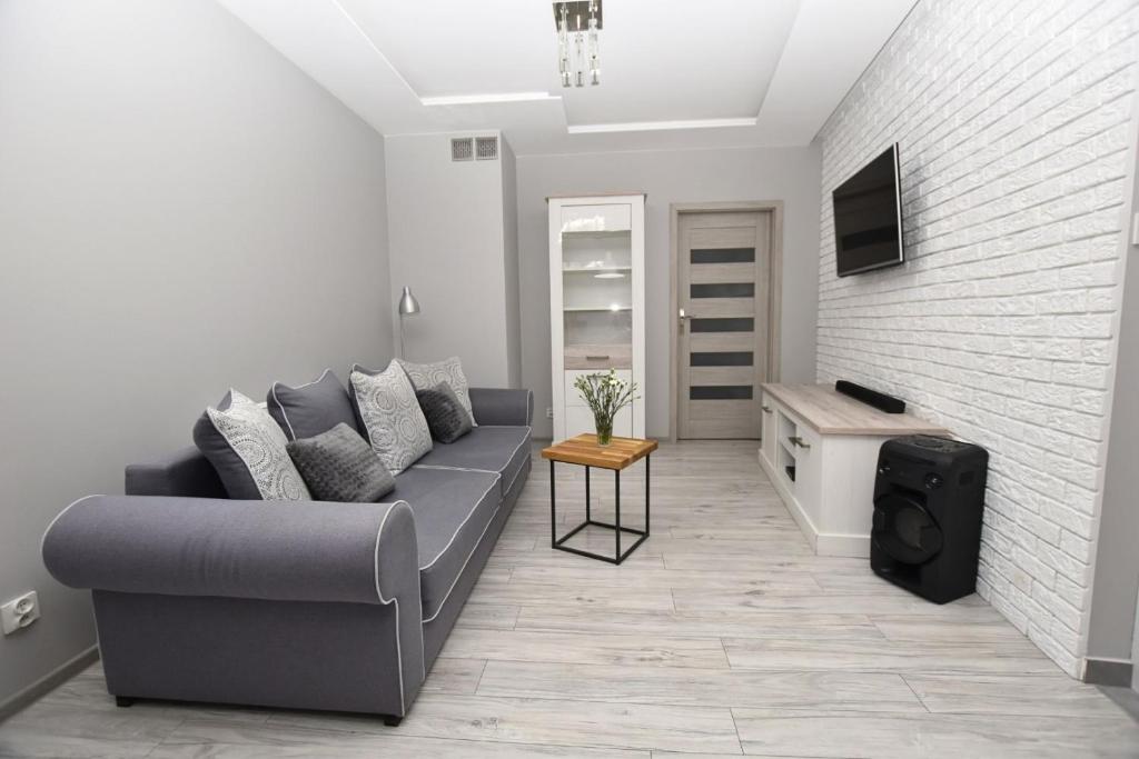 a living room with a couch and a table at Apartament przy Starówce in Elblag