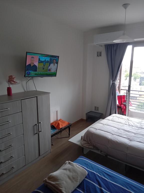 una camera con letto e TV a parete di Apartamento en Buenos Aires equipado con balcon y terraza a Buenos Aires