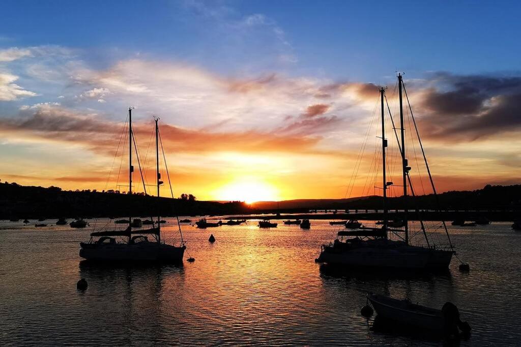 a group of boats in the water at sunset at The View in Teignmouth