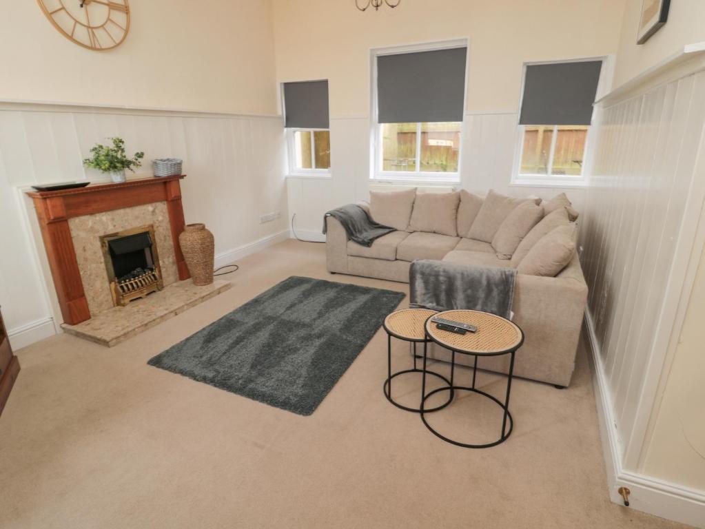 a living room with a couch and a fireplace at Courtyard Cottage in Alnwick