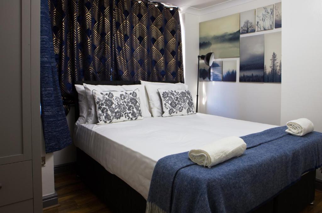 Hatch EndにあるSleek 3Bed/3Bathroom Flat@Harrowのベッドルーム1室(大型ベッド1台、青い毛布付)
