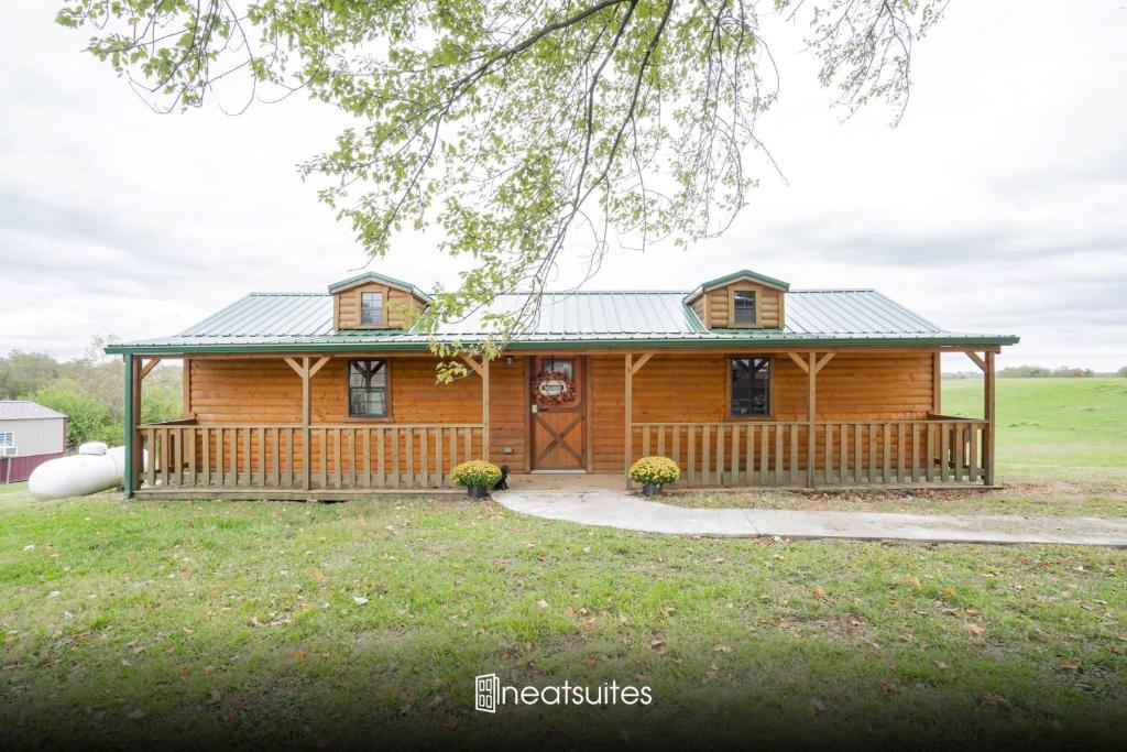 a log cabin with a porch and a yard at Cozy Cabin near Ark! Adam and Eve's Retreat in Williamstown