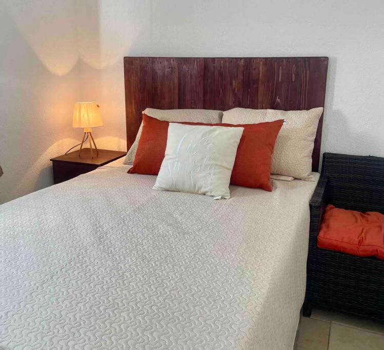 1 dormitorio con 1 cama grande con almohadas rojas y blancas en Ecoterra House Santa Ana 