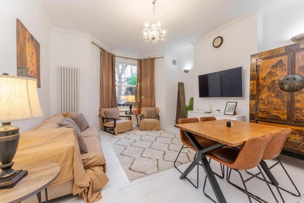 a living room with a bed and a table at Spacious and modern London duplex apartment with garden in London