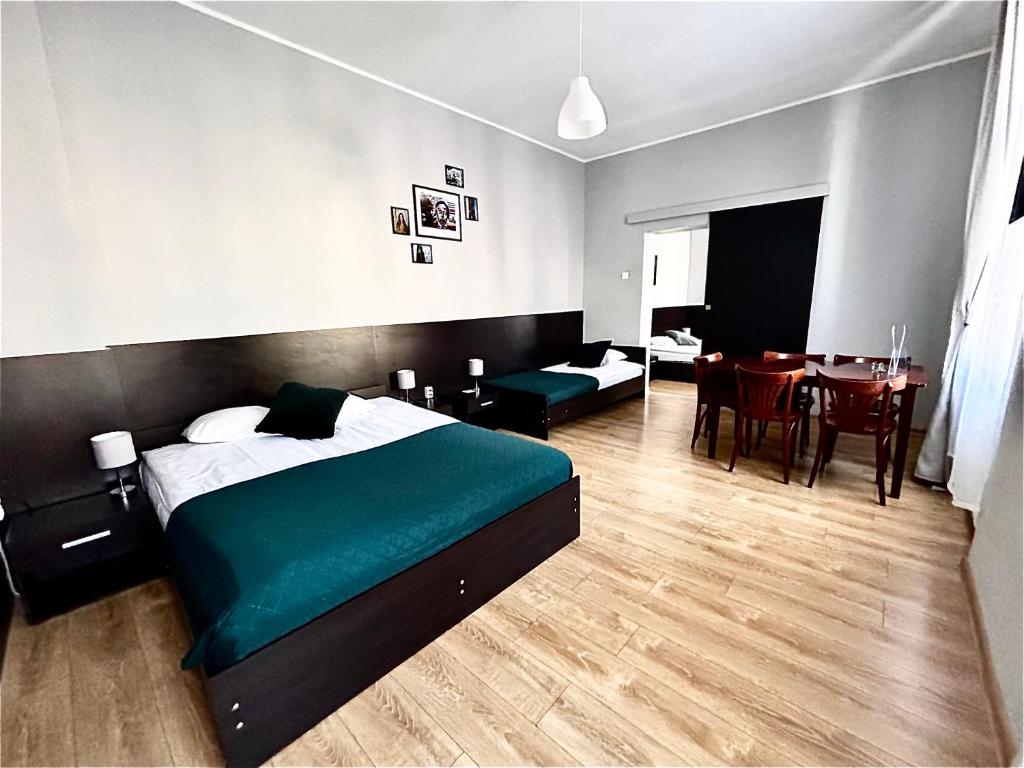 sypialnia z dużym łóżkiem i jadalnią w obiekcie BedRooms Piotrkowska 64 w Łodzi
