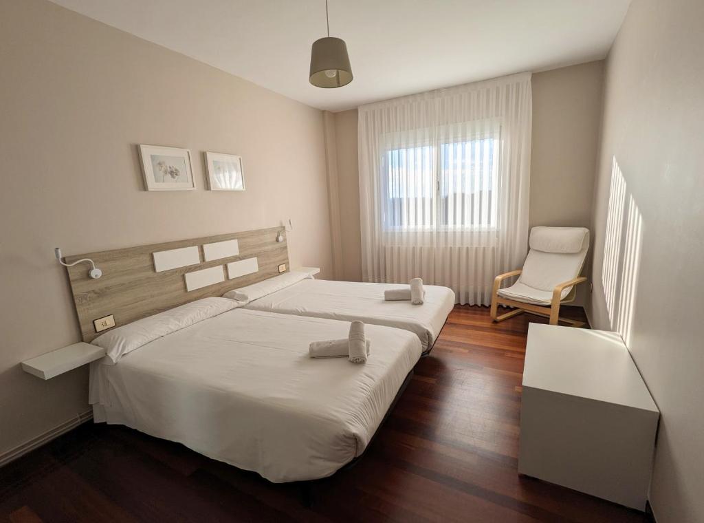 1 dormitorio con 1 cama grande y 1 silla en Apartamentos Turísticos Guillermo en Palas de Rei 