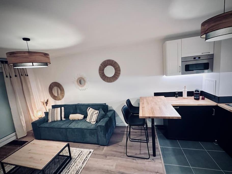 uma sala de estar com um sofá verde e uma cozinha em Appartement cosy em Meaux