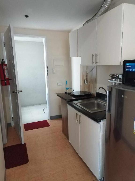 a small kitchen with a sink and a refrigerator at Sunvida Tower Condominium in Cebu City