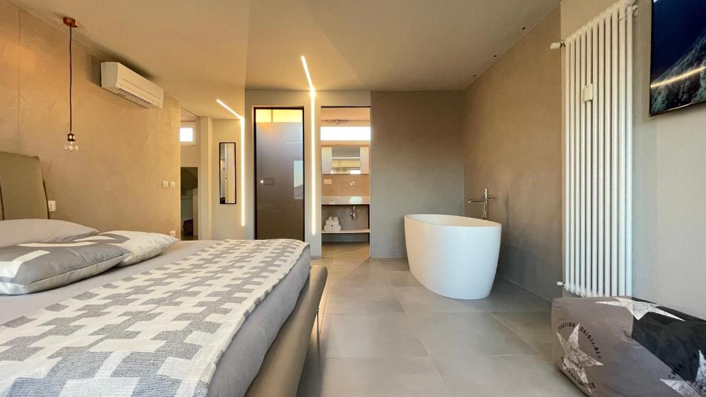 a bedroom with a large bed and a bath tub at Mediceo 42 in Pisa
