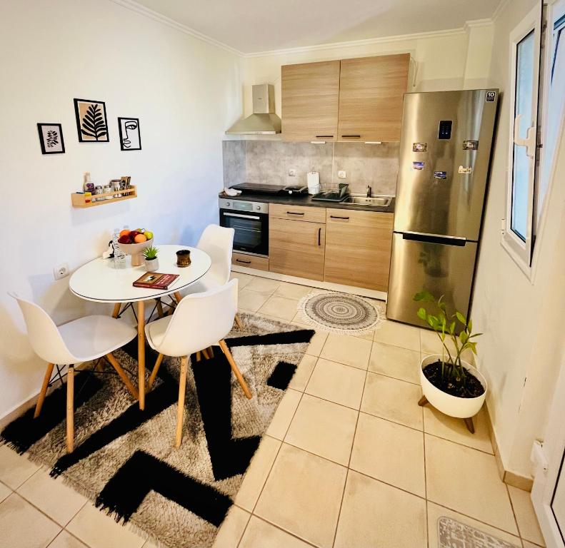 een keuken met een tafel en stoelen en een koelkast bij S&A Modern Apartment in Igoumenitsa