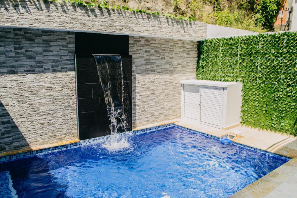 basen z wodospadem w ogrodzie w obiekcie Hermosa Casa en Girardot con Piscina Privada w mieście Girardot
