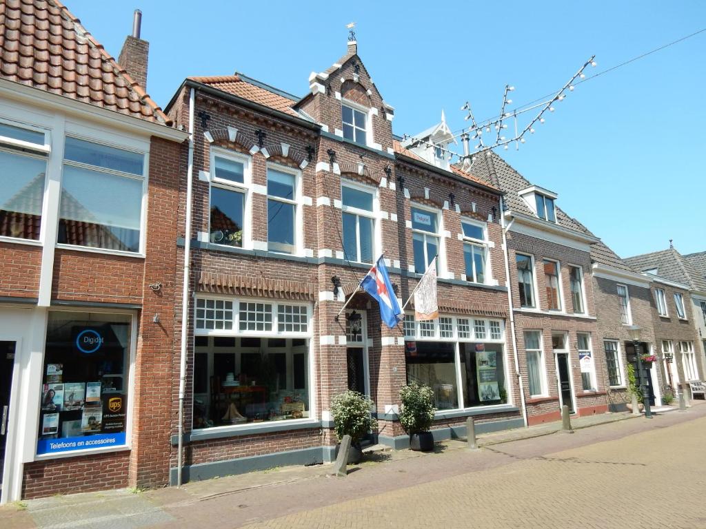 a brick building on a street in a city at Gasthuis In de Heilige Stede in Hasselt