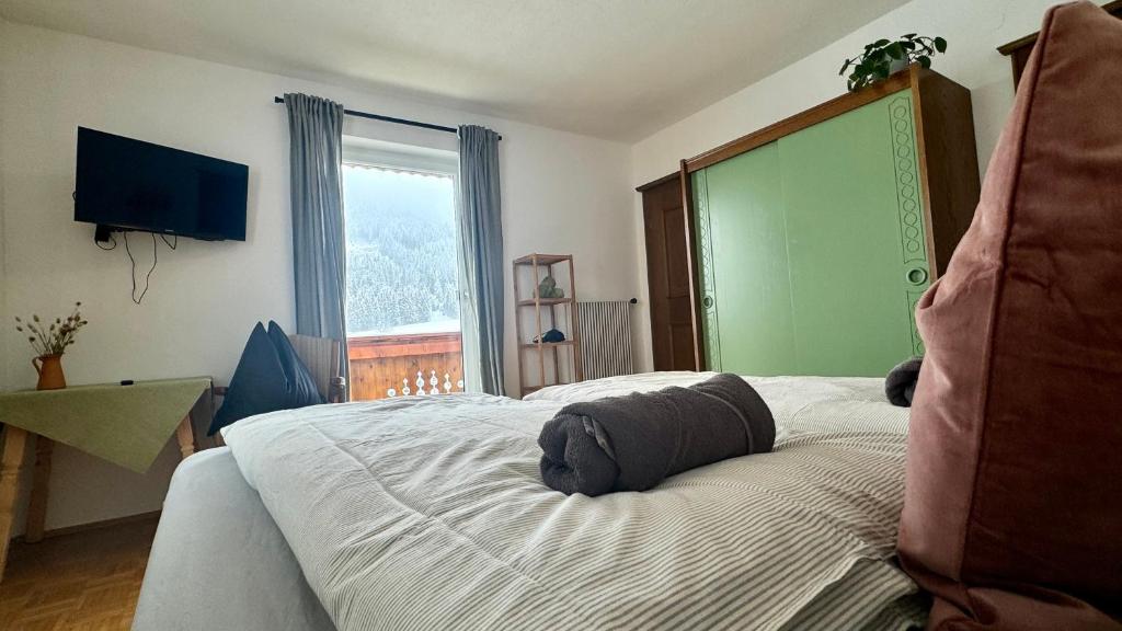 a bedroom with a bed and a large window at Alpenchalet Basecamp Apartment 1 in Sankt Martin am Tennengebirge