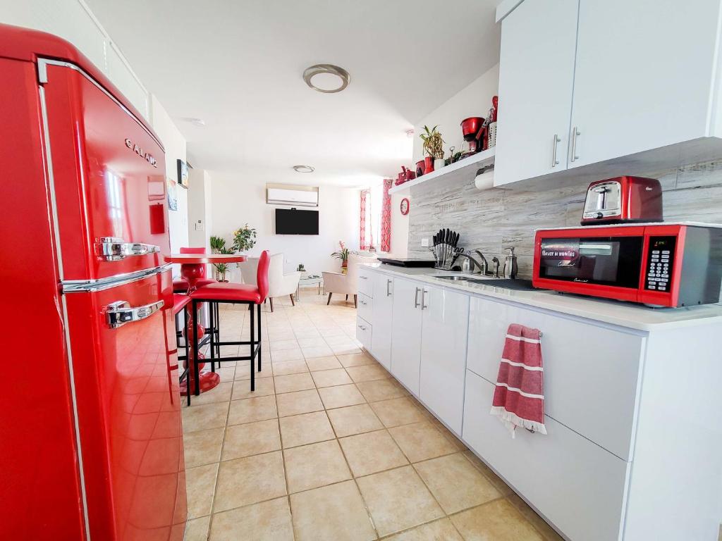 een keuken met een rode koelkast en een tafel bij Paradise Beach Home @Jobos beach in Isabela