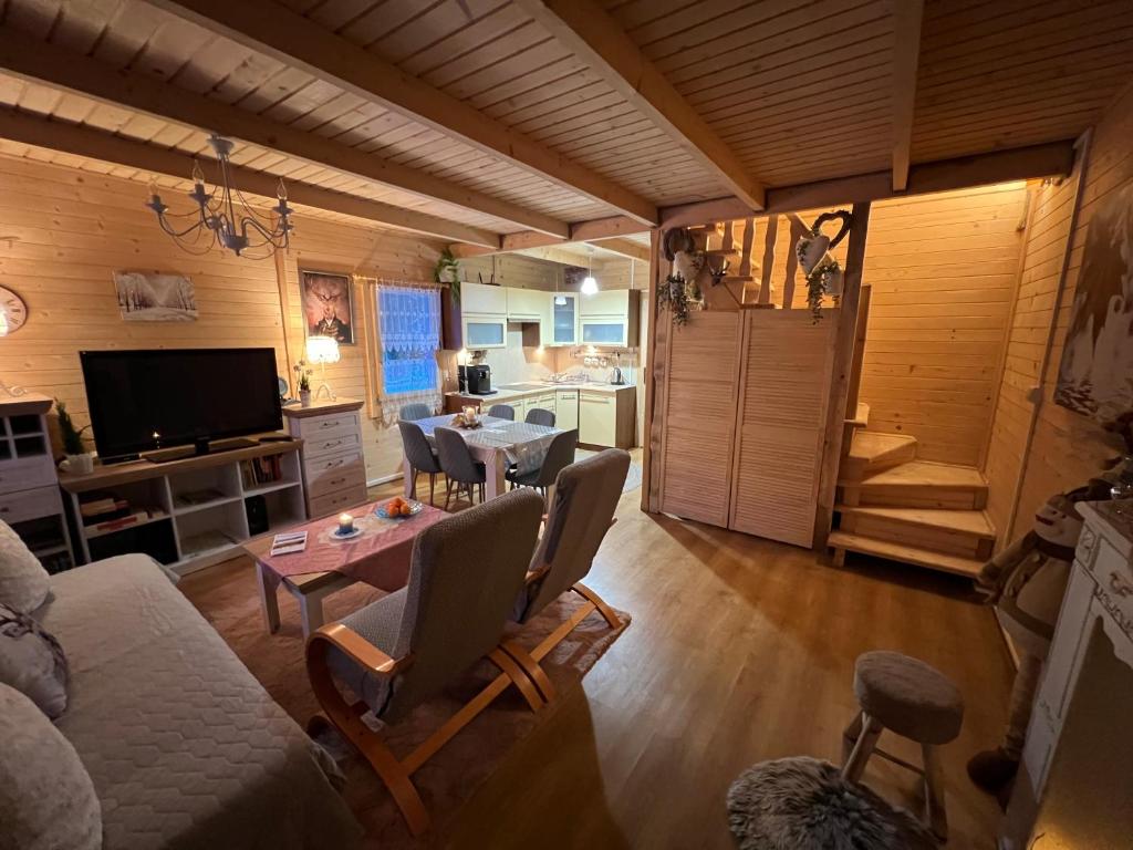 a living room with a table and chairs and a kitchen at Ustronne Chatki - Ostoja nad Potokiem in Ustroń