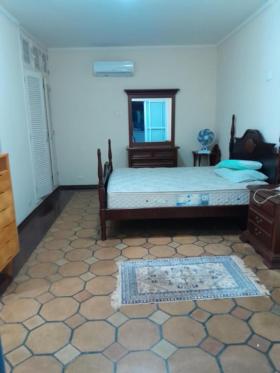 1 dormitorio con cama y espejo. en Mansão Mar casado en Guarujá