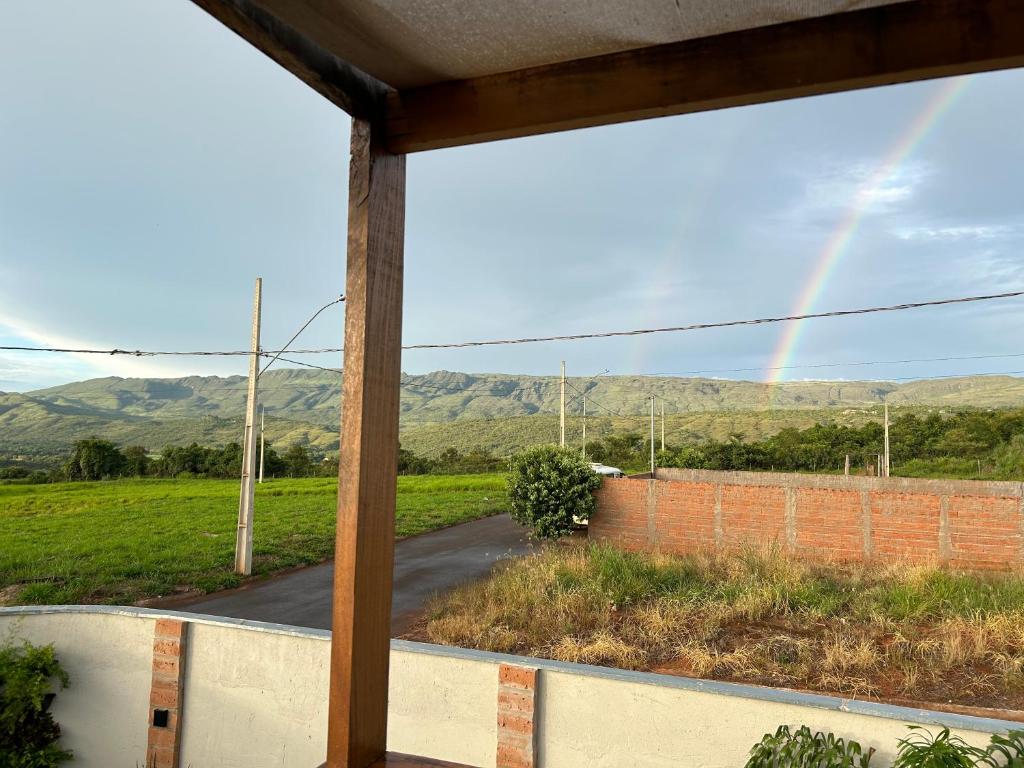 een regenboog van het raam van een huis bij Chalé vista da serra in Delfinópolis