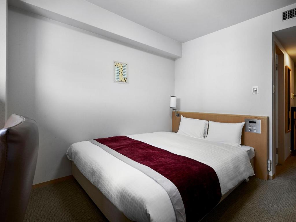 Postel nebo postele na pokoji v ubytování Daiwa Roynet Hotel Hiroshima