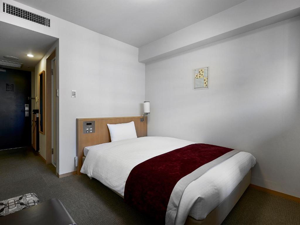 Postel nebo postele na pokoji v ubytování Daiwa Roynet Hotel Hiroshima
