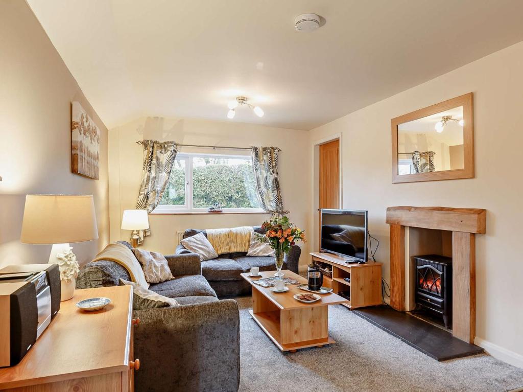 a living room with a couch and a fireplace at 2 Bed in Betws y coed 80629 in Gwytherin