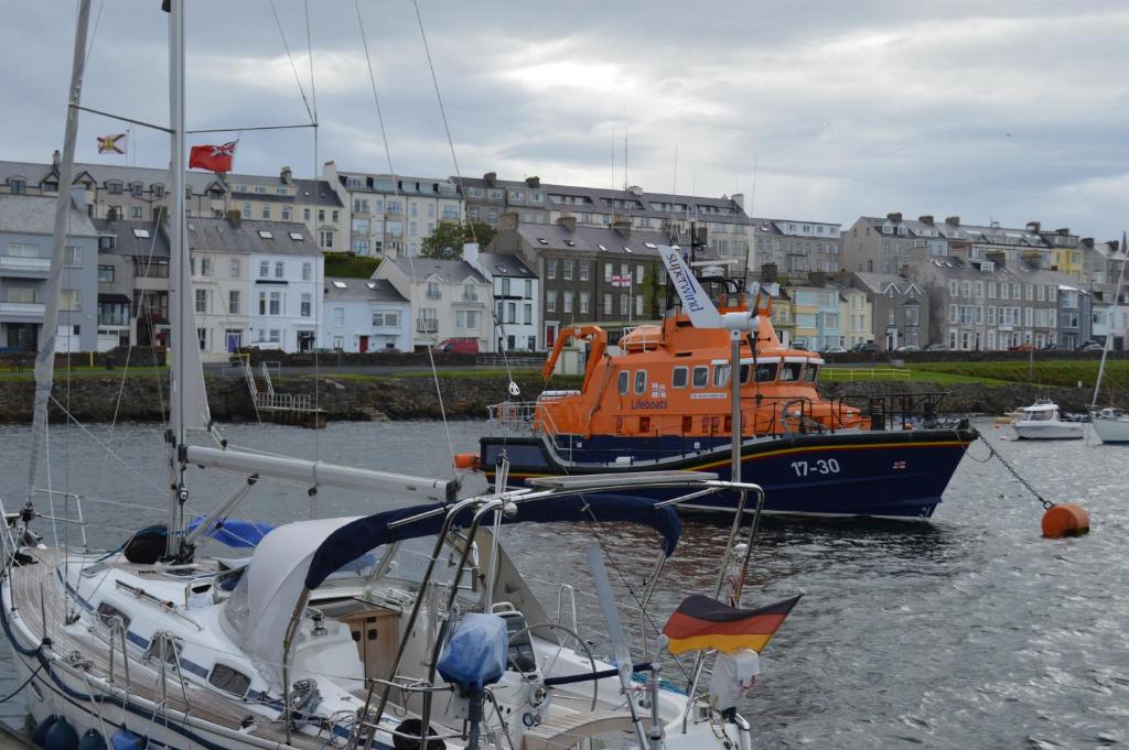 two boats are docked in a harbor with buildings at Pier39Portrush Adult Only in Portrush