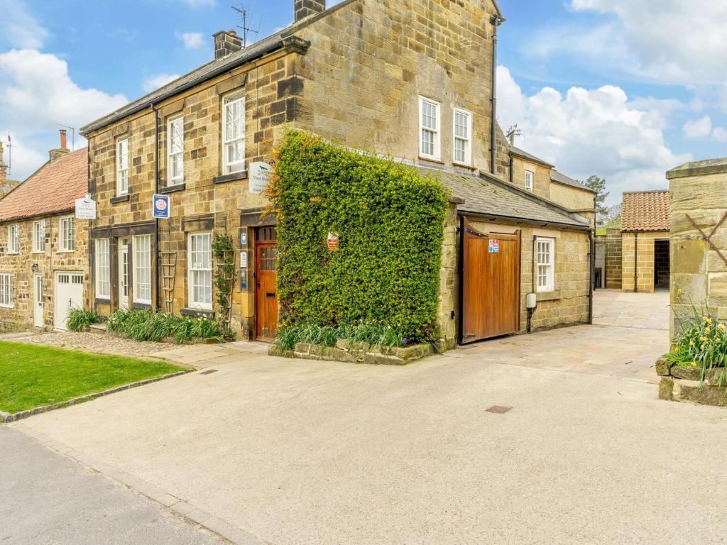 an ivy covered brick house with a garage at 1 Bed in Osmotherley 91336 in Osmotherley