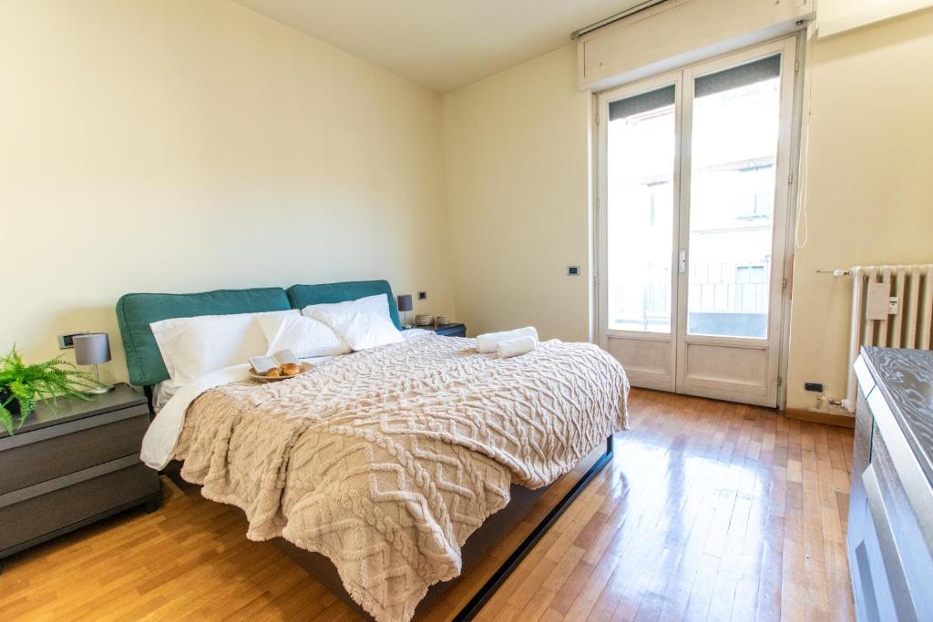 ein Schlafzimmer mit einem Bett und einem großen Fenster in der Unterkunft [IHost Apartment] - Niccolini 21 in Mailand