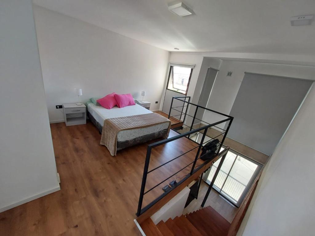 een slaapkamer met een bed met roze kussens erop bij Departamento en MDP in Mar del Plata
