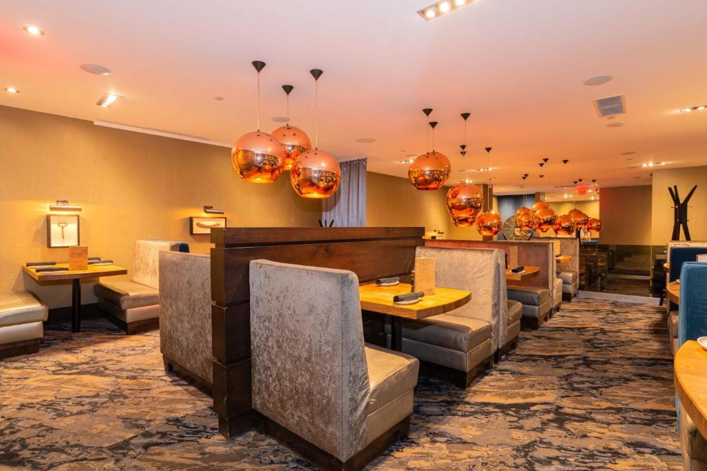 a restaurant with chairs and tables and chandeliers at Sandman Signature Edmonton Downtown Hotel in Edmonton