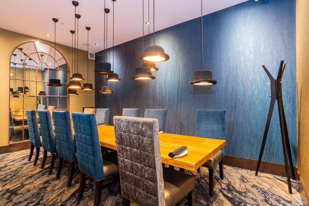 a dining room with a wooden table and blue chairs at Sandman Signature Edmonton Downtown Hotel in Edmonton