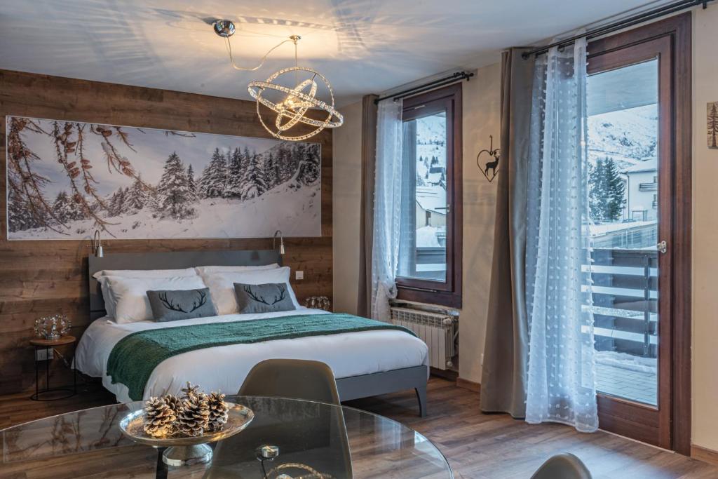 a bedroom with a bed and a large window at Diamante ampio monolocale stile chalet alpino in Passo del Tonale