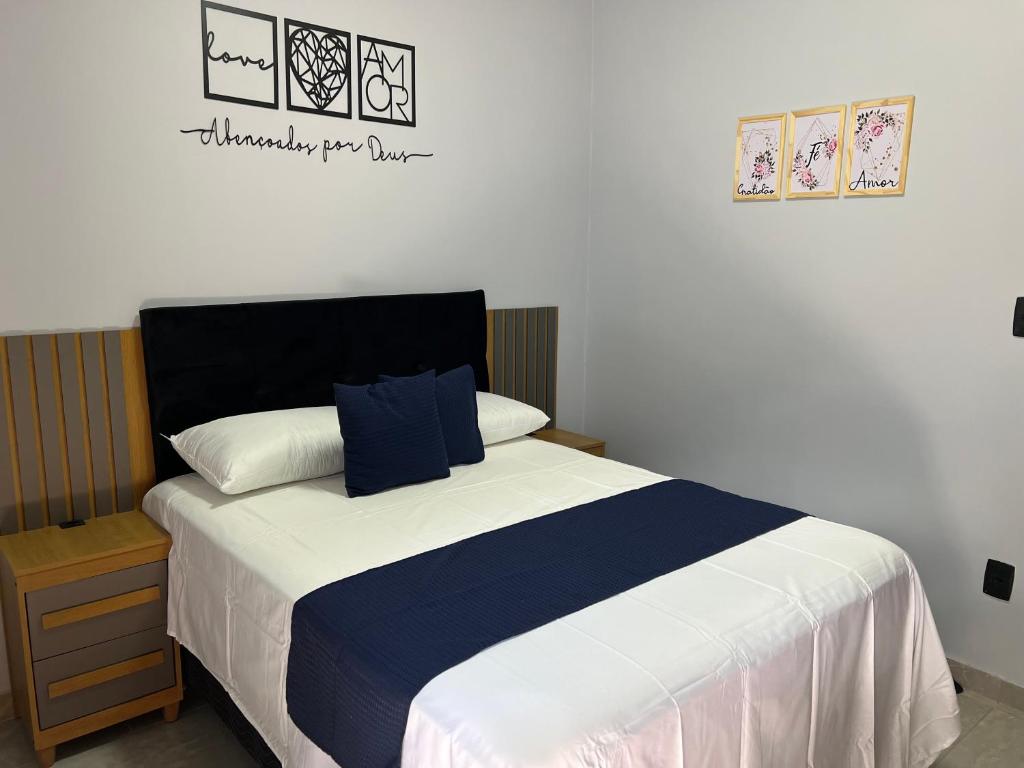 a bedroom with a bed with a blue and white blanket at Kitnets Cidade de Goiás-Go 02 in Goiás