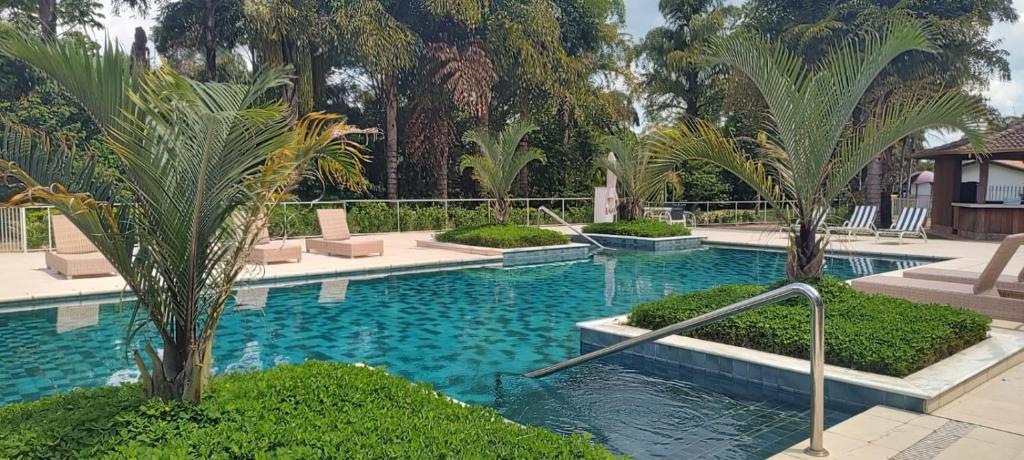 una piscina con palme in un resort di Radio Hotel Resort & Convention a Serra Negra
