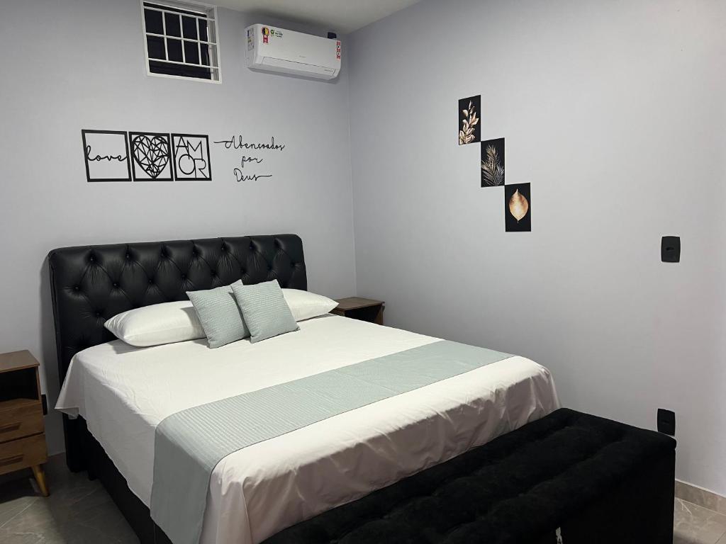 a bedroom with a large bed with a black headboard at Kitnet Cidade de Goiás - Go #02 in Goiás