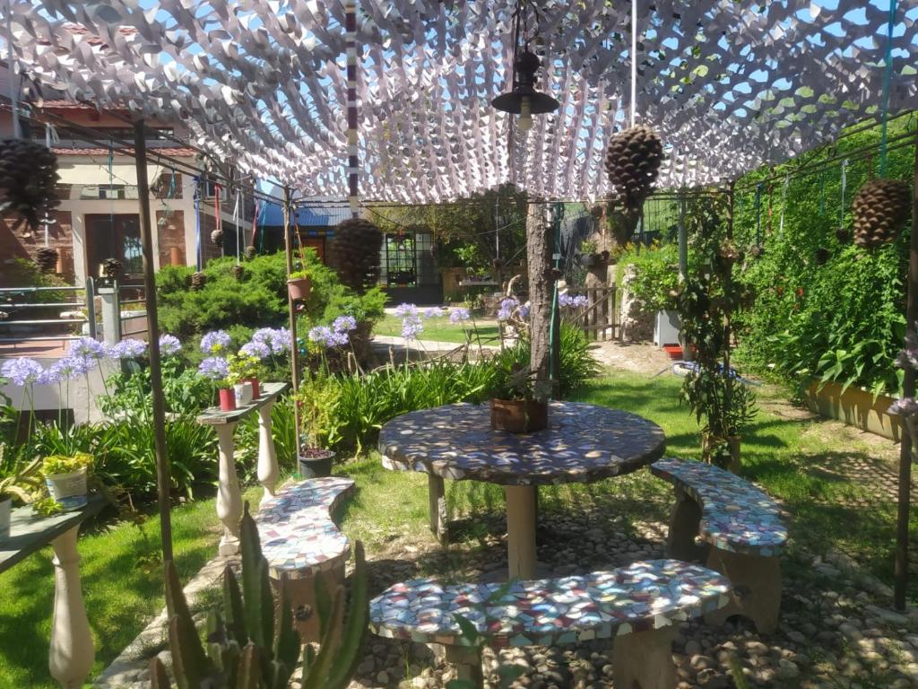 d'une terrasse avec une table et des chaises dans le jardin. dans l'établissement Departamento los lapachos, à Villa Allende