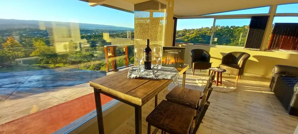 Una habitación con una mesa con una botella de vino. en AYRES SUITE en Villa Carlos Paz