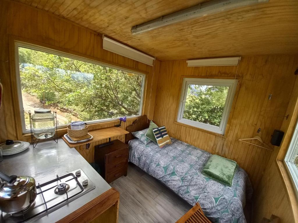 a small room with a bed and a window at Casa árbol Conguillio National Park in Melipeuco