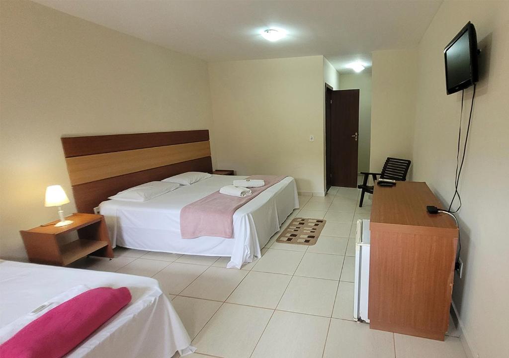 a hotel room with a bed and a television at Acquamarine Park Hotel in Guarapari