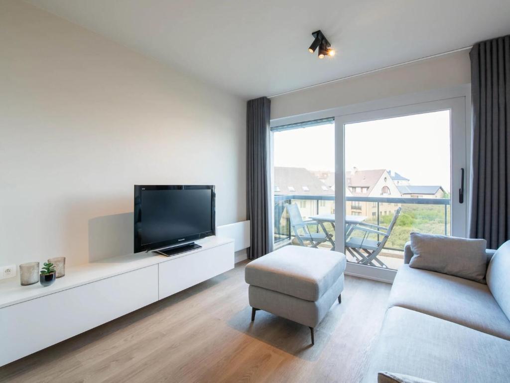 sala de estar con TV de pantalla plana y sofá en Plaza Z22 located near the beach, en Oostduinkerke