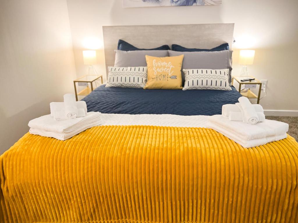 a bedroom with a large bed with a yellow blanket at Downtown Modern Luxury 2BD 2BA FREE PARKING in Indianapolis