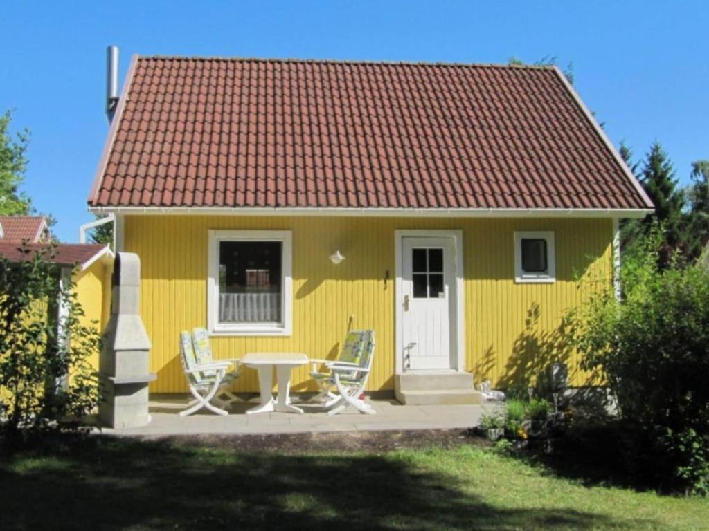 una casa amarilla con una mesa y sillas frente a ella en Holiday home Angel 2, en Warin