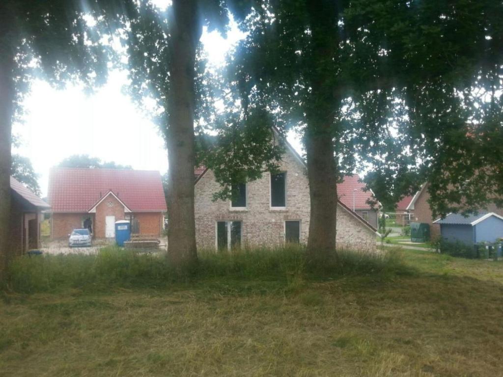 a house with two trees in front of it at Aquarius on the swimming lake in Aurich
