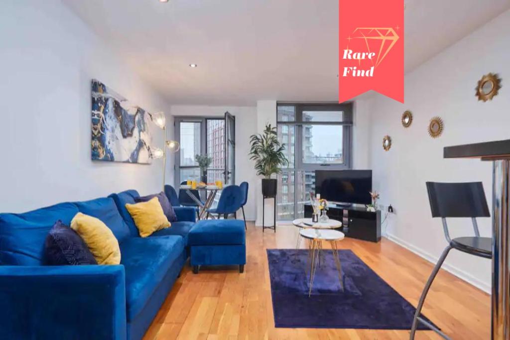 ein Wohnzimmer mit einem blauen Sofa und einem Tisch in der Unterkunft Spacious 4 Beds Apt - Perfect for Families, Contractors & FREE Parking in Leeds