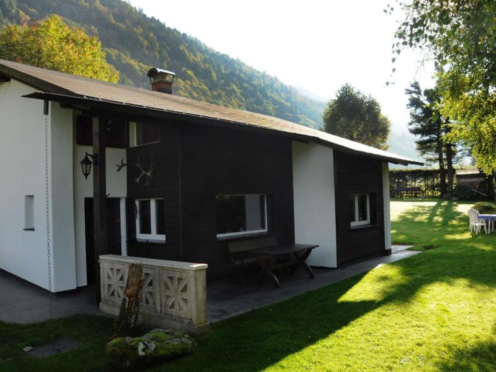 uma casa a preto e branco com um jardim de relva em Holiday home Feldbergblick em Hintertal