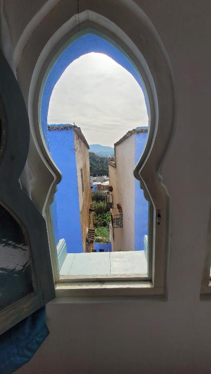 an arched window in a building with a view at Honey Suckle in Chefchaouene
