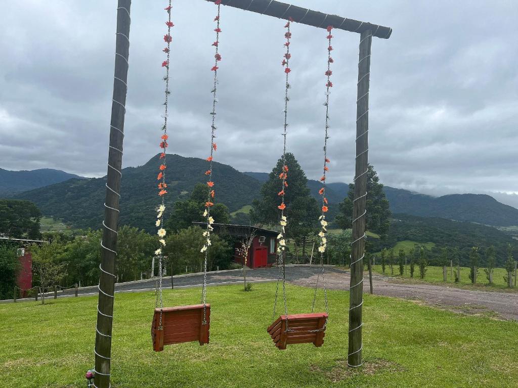 a swing set in a park with mountains in the background at Chalés incríveis com banheira de hidromassagem e vista encantadora in Urubici